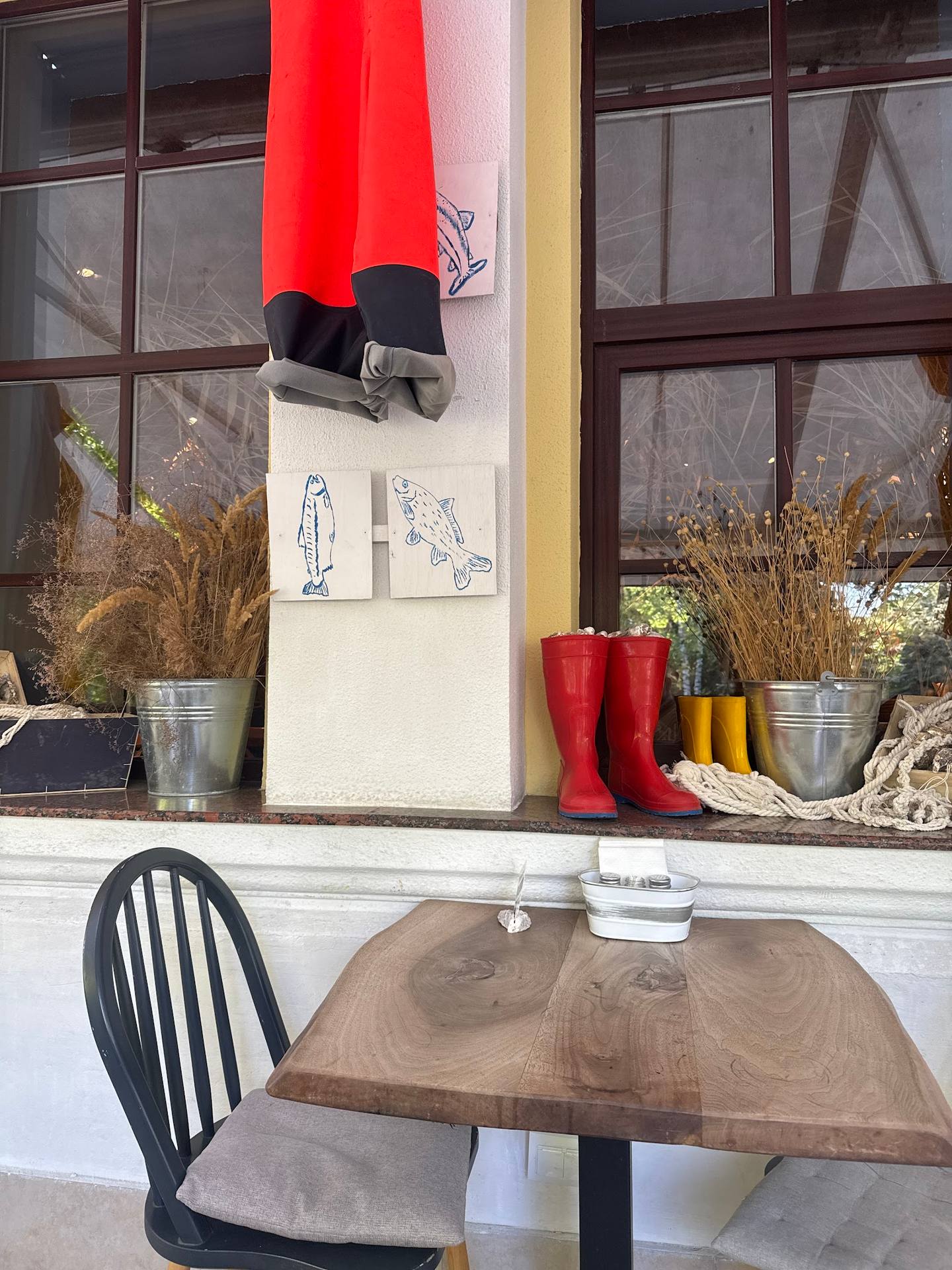 Storefront window display with clothing mannequin and red boots
