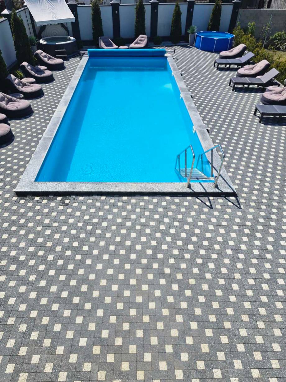 Resort pool deck with loungers and blue rectangular swimming pool
