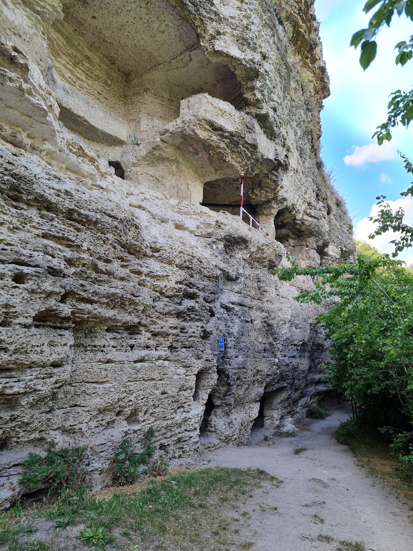 Medieval fortress cliff with carved chambers and stone facade