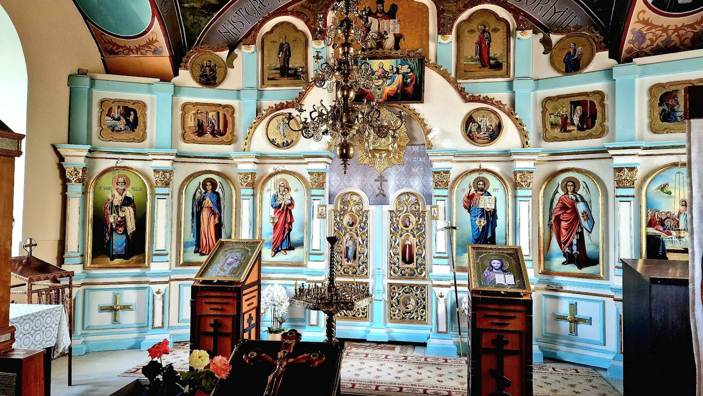 Orthodox monastery interior with ornate iconostasis and religious artwork