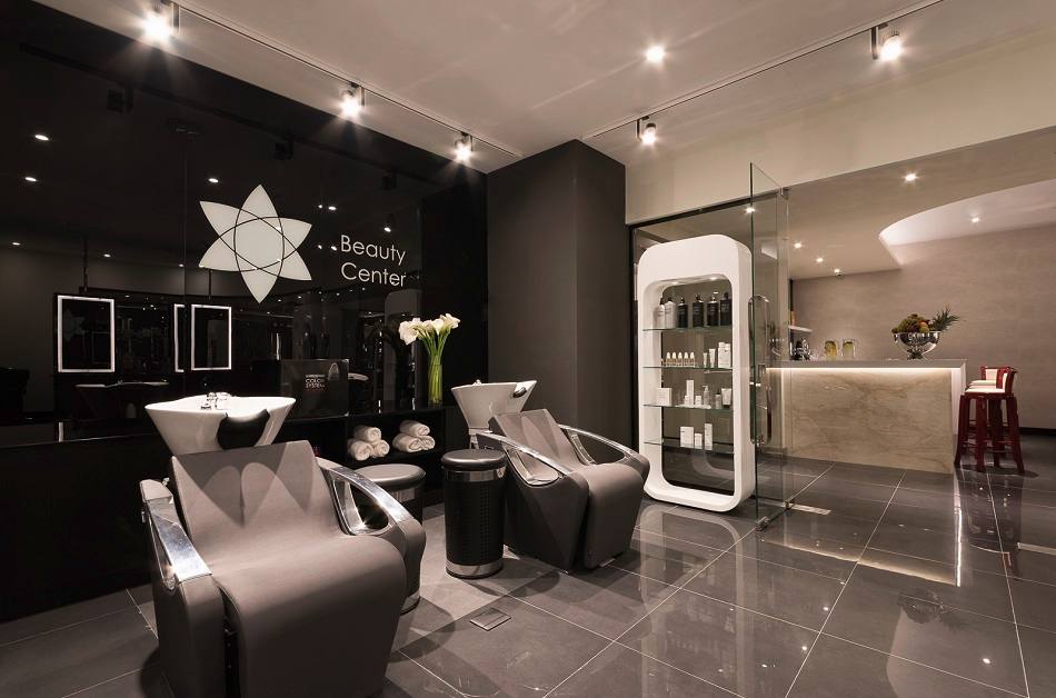Modern spa interior with elegant black and white decor, lounge seating, and professional treatment stations