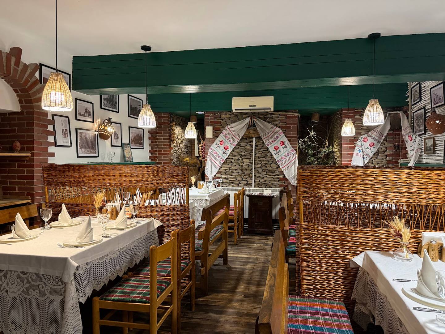 Intimate dining room with exposed brick walls, forest green accent ceiling, and traditional wooden furniture