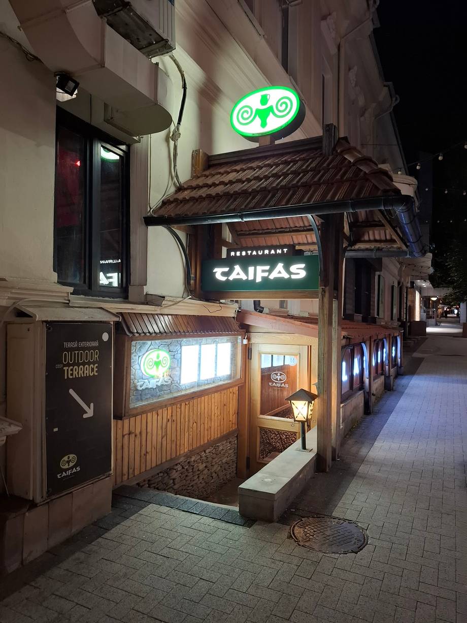 Restaurant Caifas storefront with illuminated signage at night