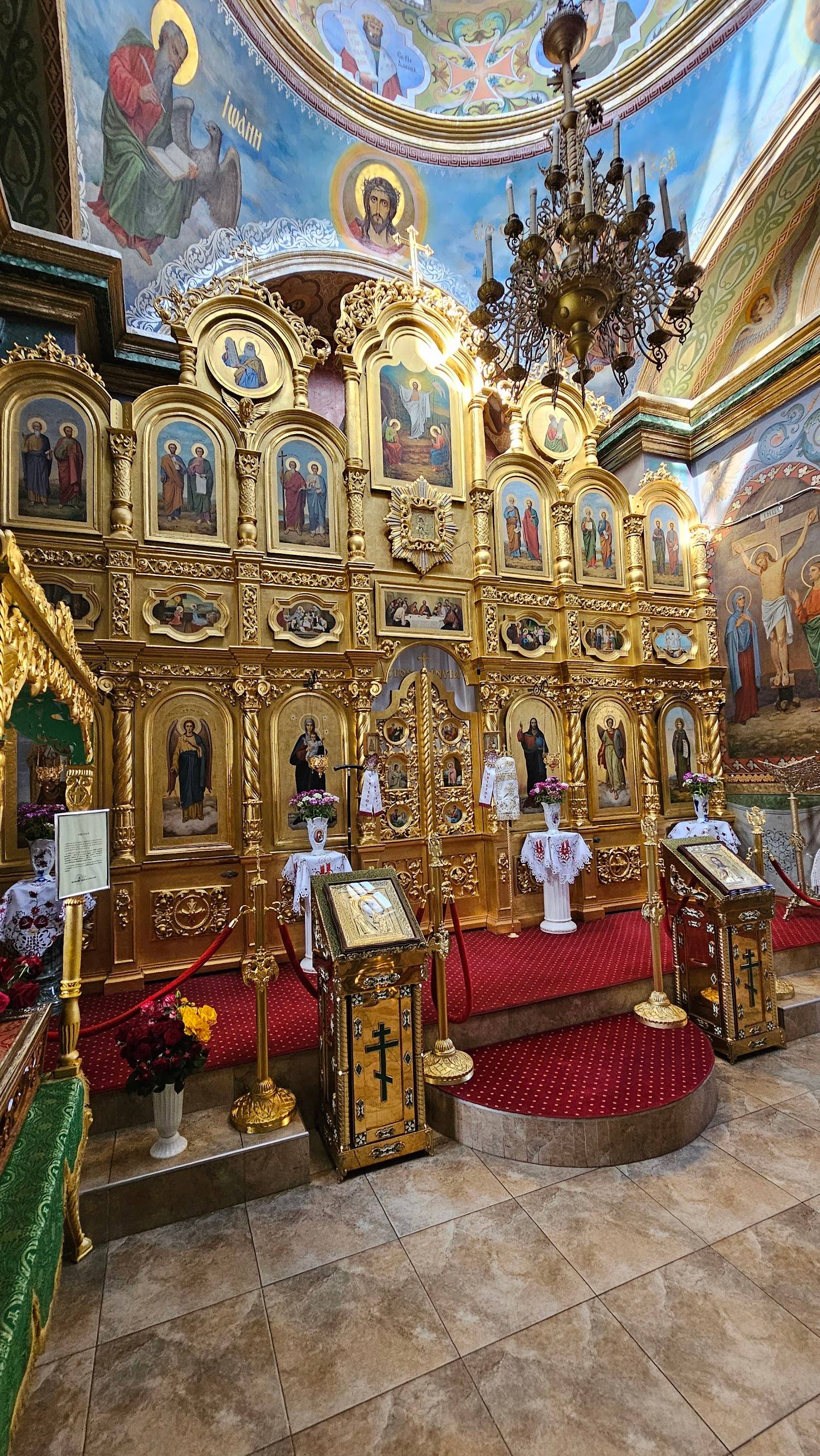 Orthodox monastery interior with ornate golden iconostasis and frescoed ceiling