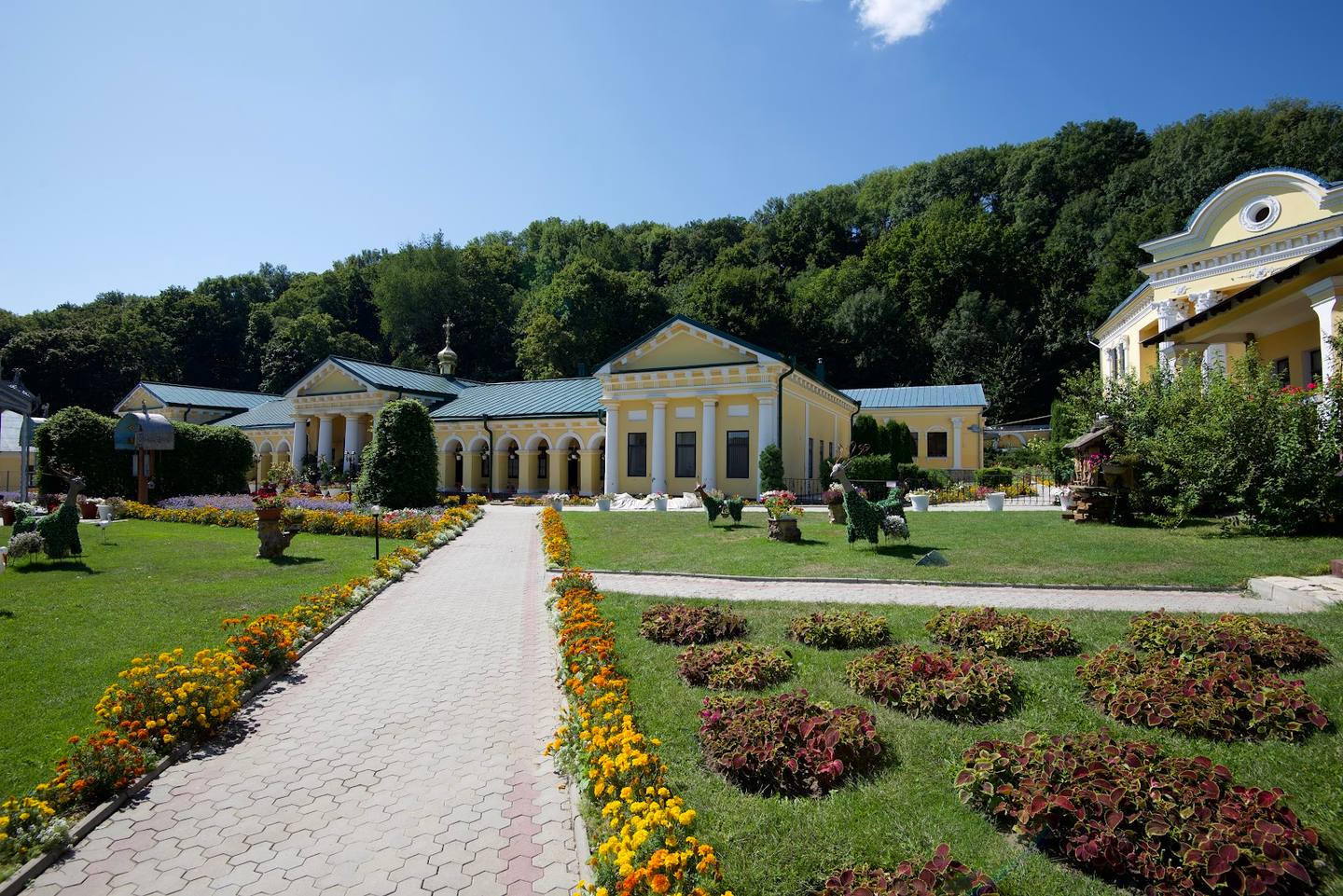 Classical monastery compound with manicured gardens and neoclassical architecture under clear sky