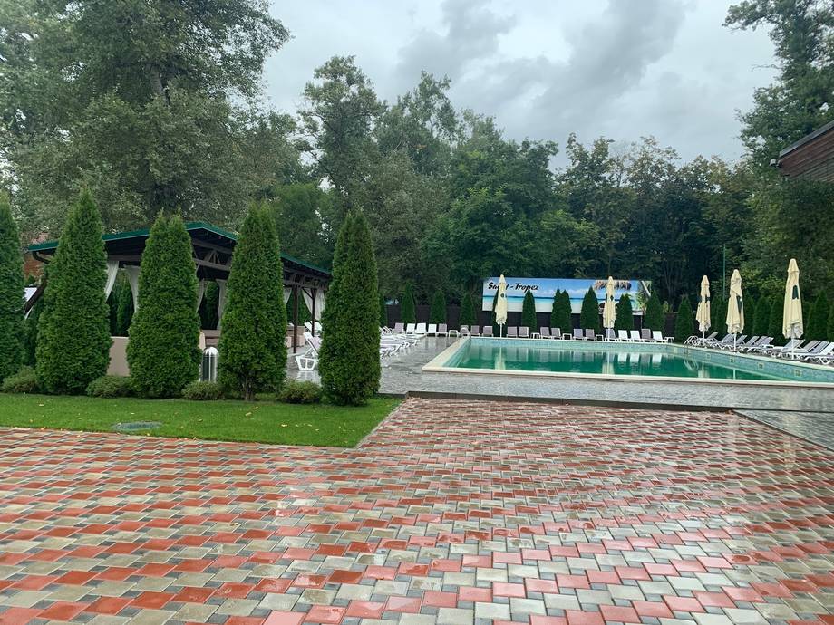 Poolside terrace with manicured grounds and main building in background