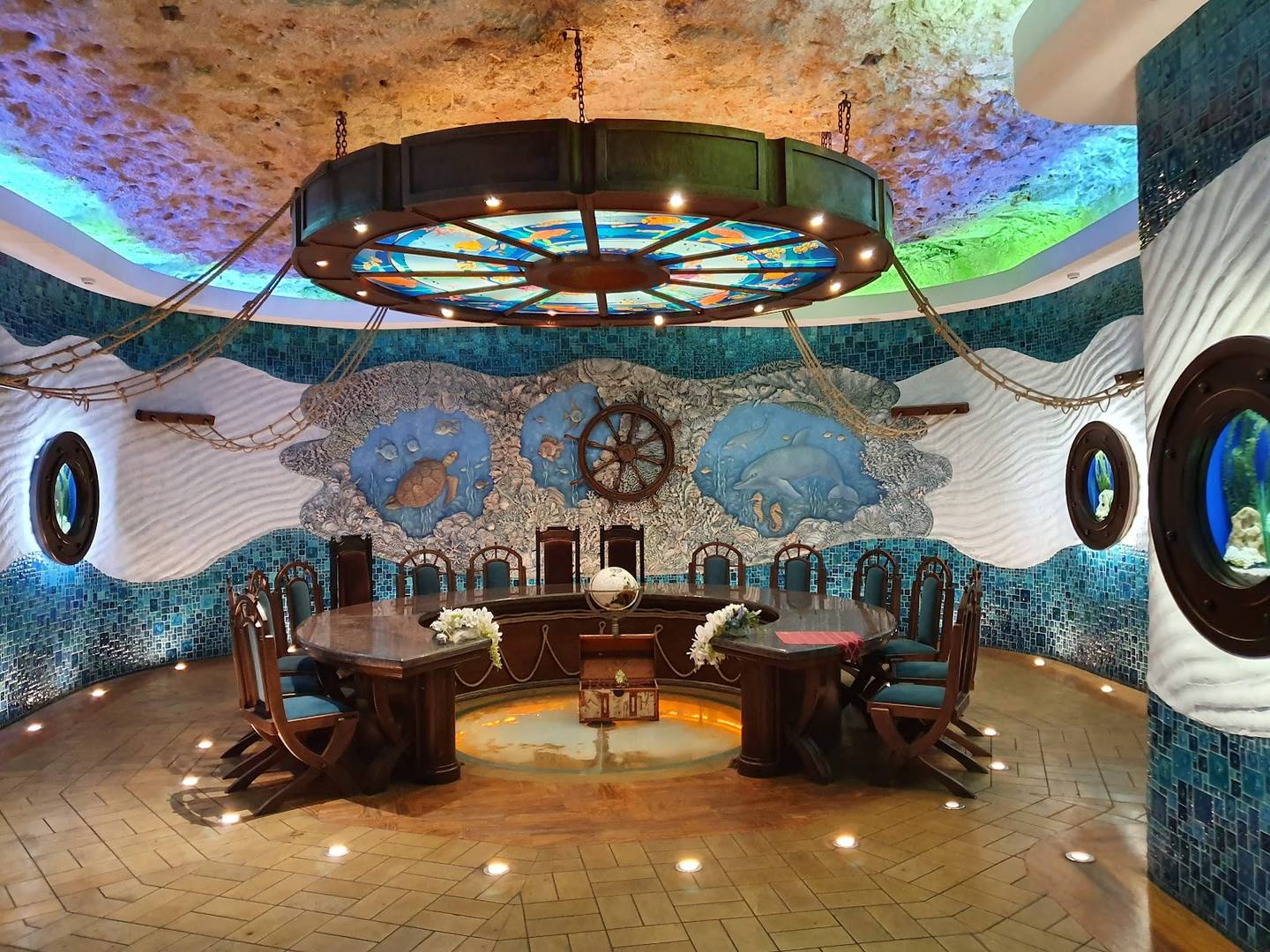 Whimsical underwater-themed dining room with sculptural ceiling, mosaic walls, and artistic lighting