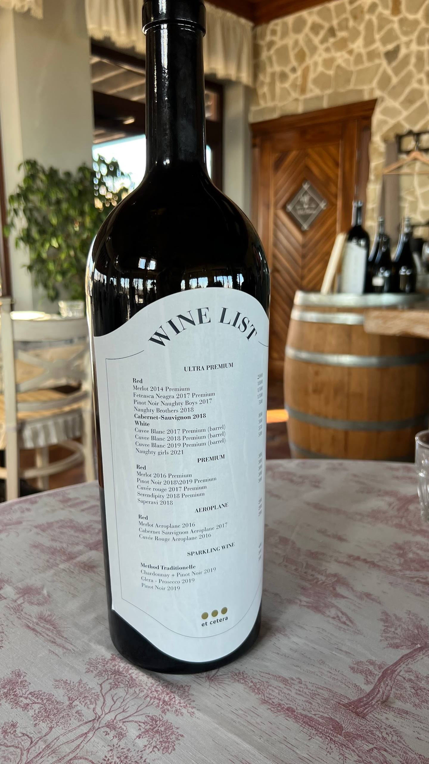 Wine bottle with tasting menu displayed on table in cellar tasting room