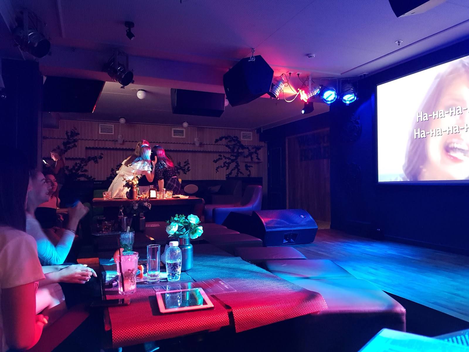 DJ booth and dance floor in an upscale nightclub with RGB ambient lighting and lounge seating