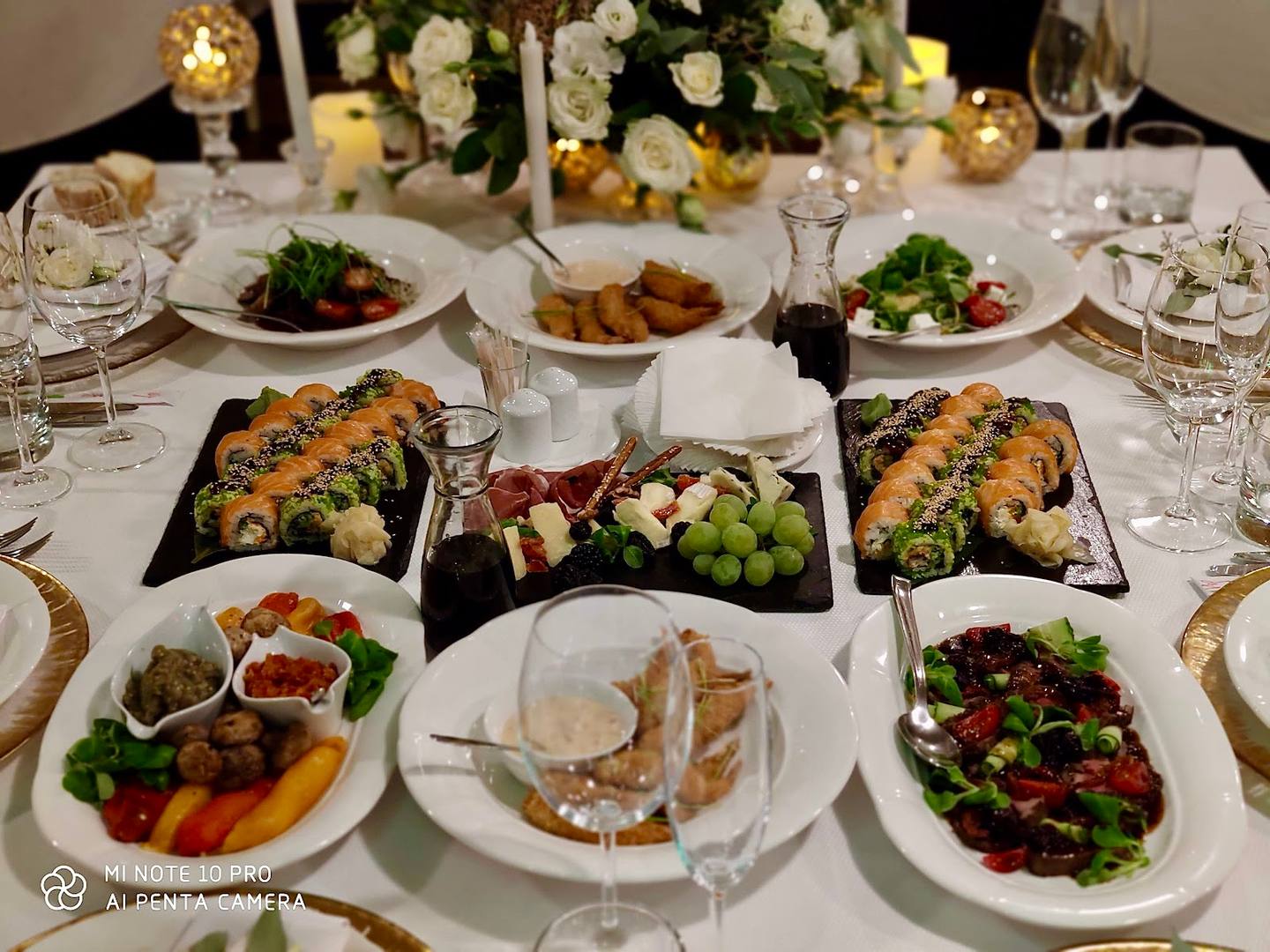 Elegantly plated multi-course spread with fish, vegetables, and white wine service