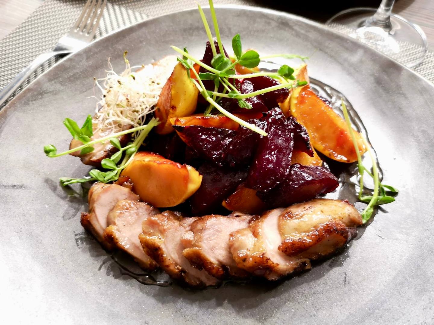 Plated duck breast with roasted beetroot and microgreens