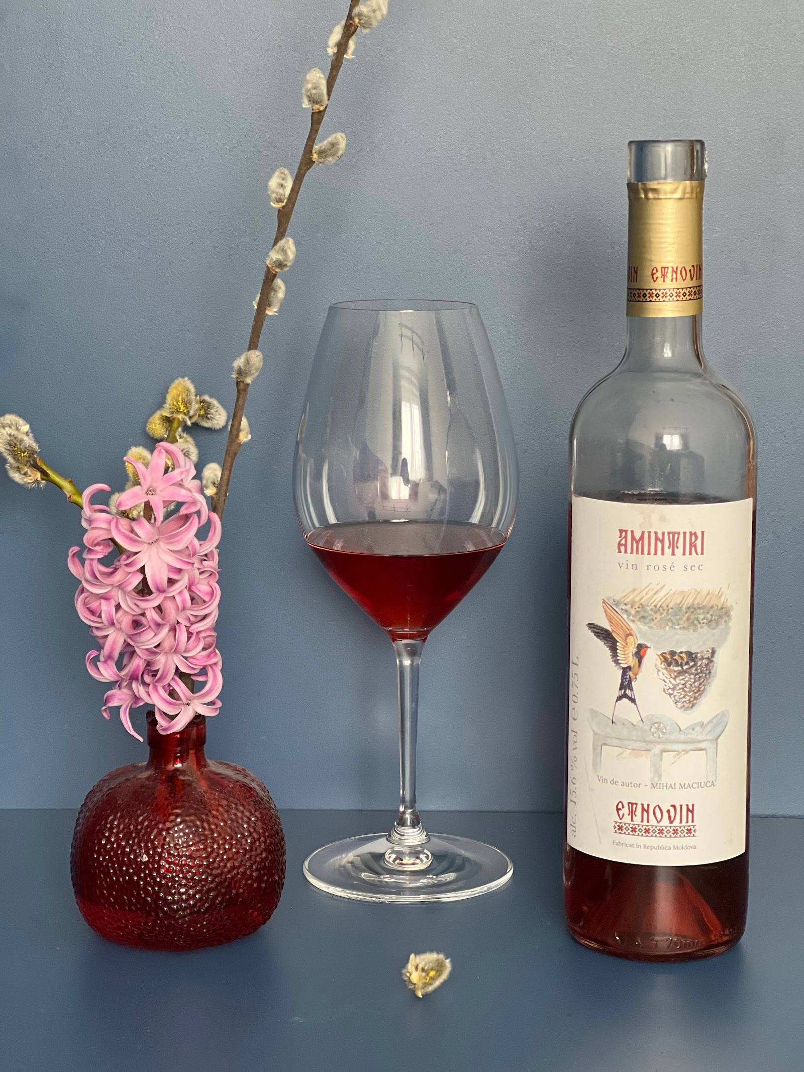 Styled wine display with rosé wine bottle, glass, and floral decoration