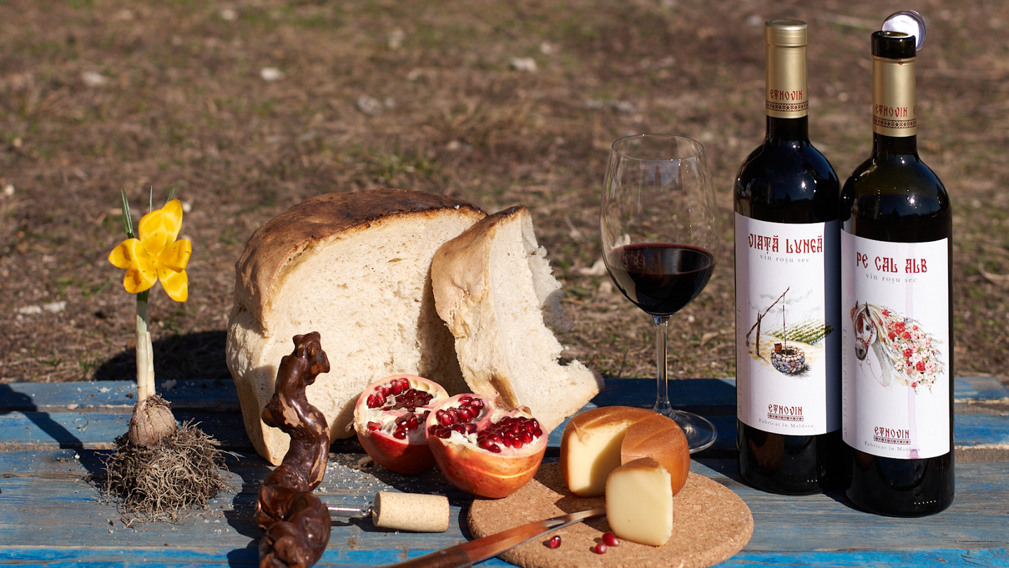 Wine and artisanal food pairing with cheeses, bread, and pomegranate