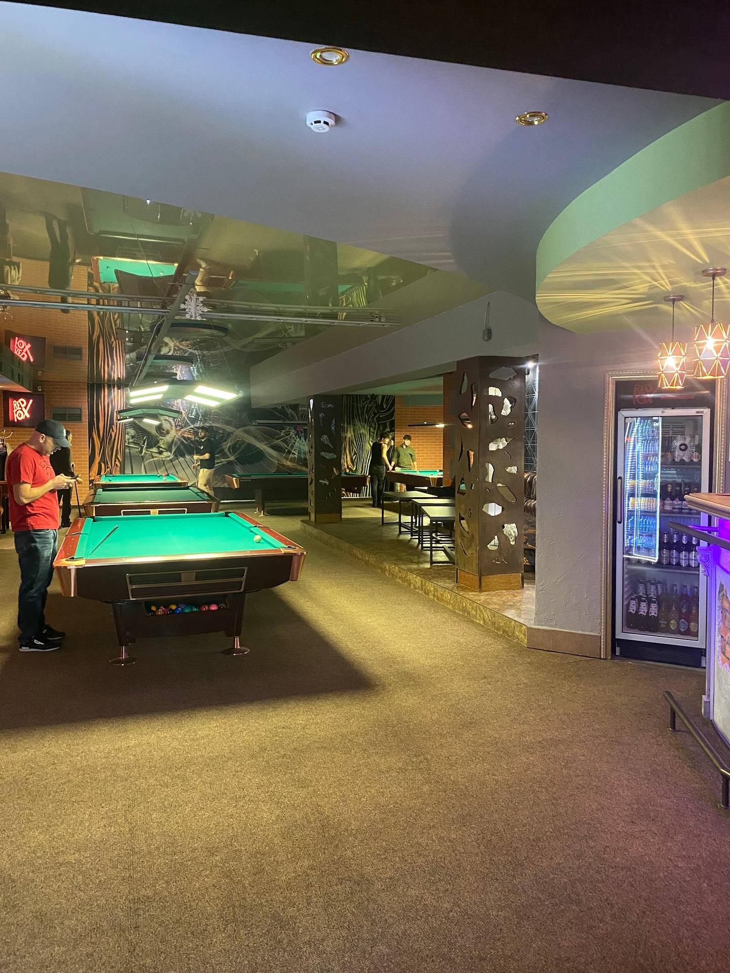 Billiards and entertainment lounge with pool tables, lighting features, and beverage coolers
