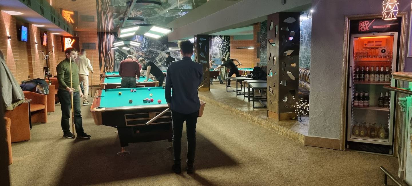Billiards hall with pool tables, bar area, and lounge seating