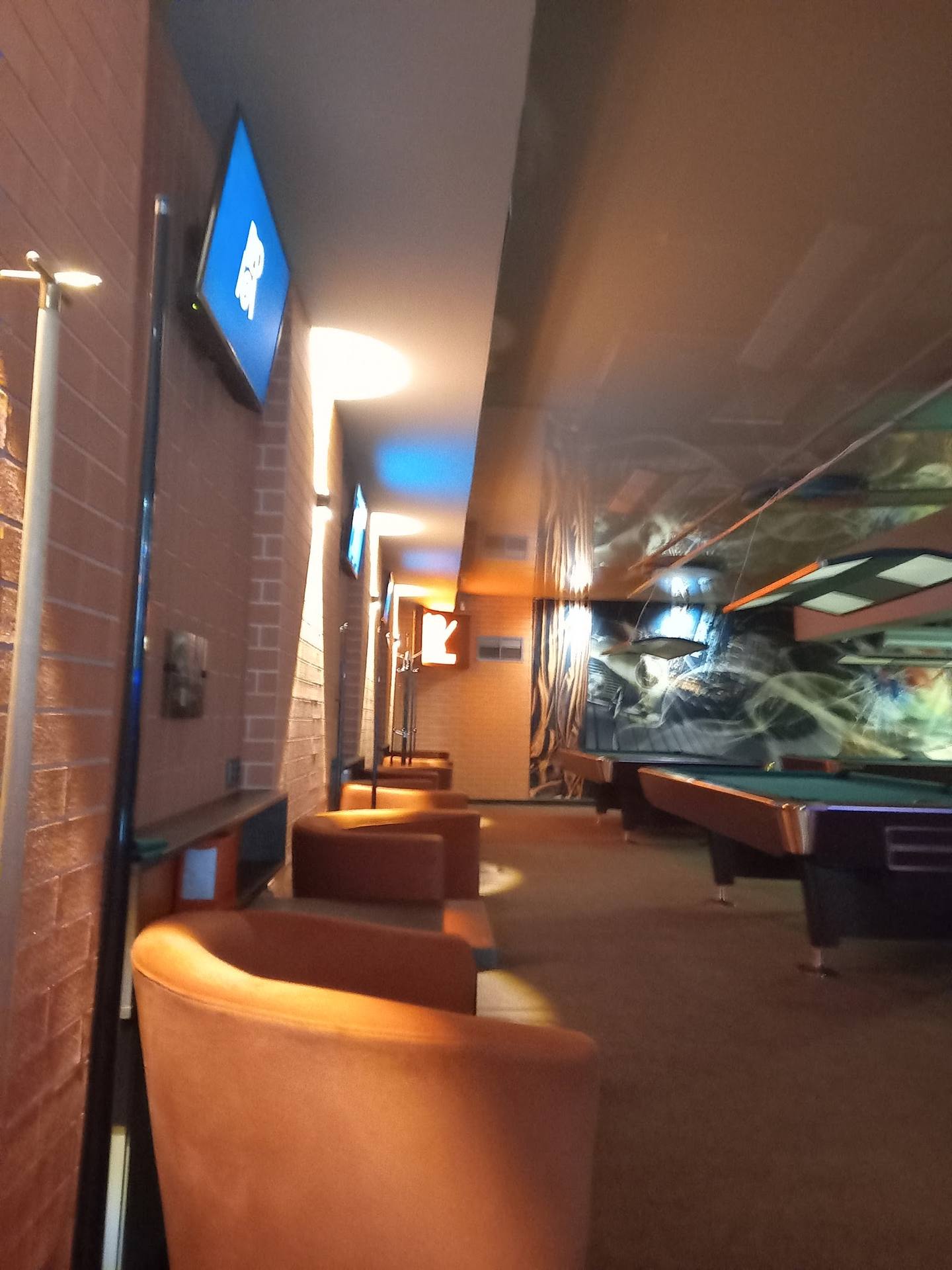 Modern interior corridor with ambient lighting, blue accent displays, and interactive exhibits