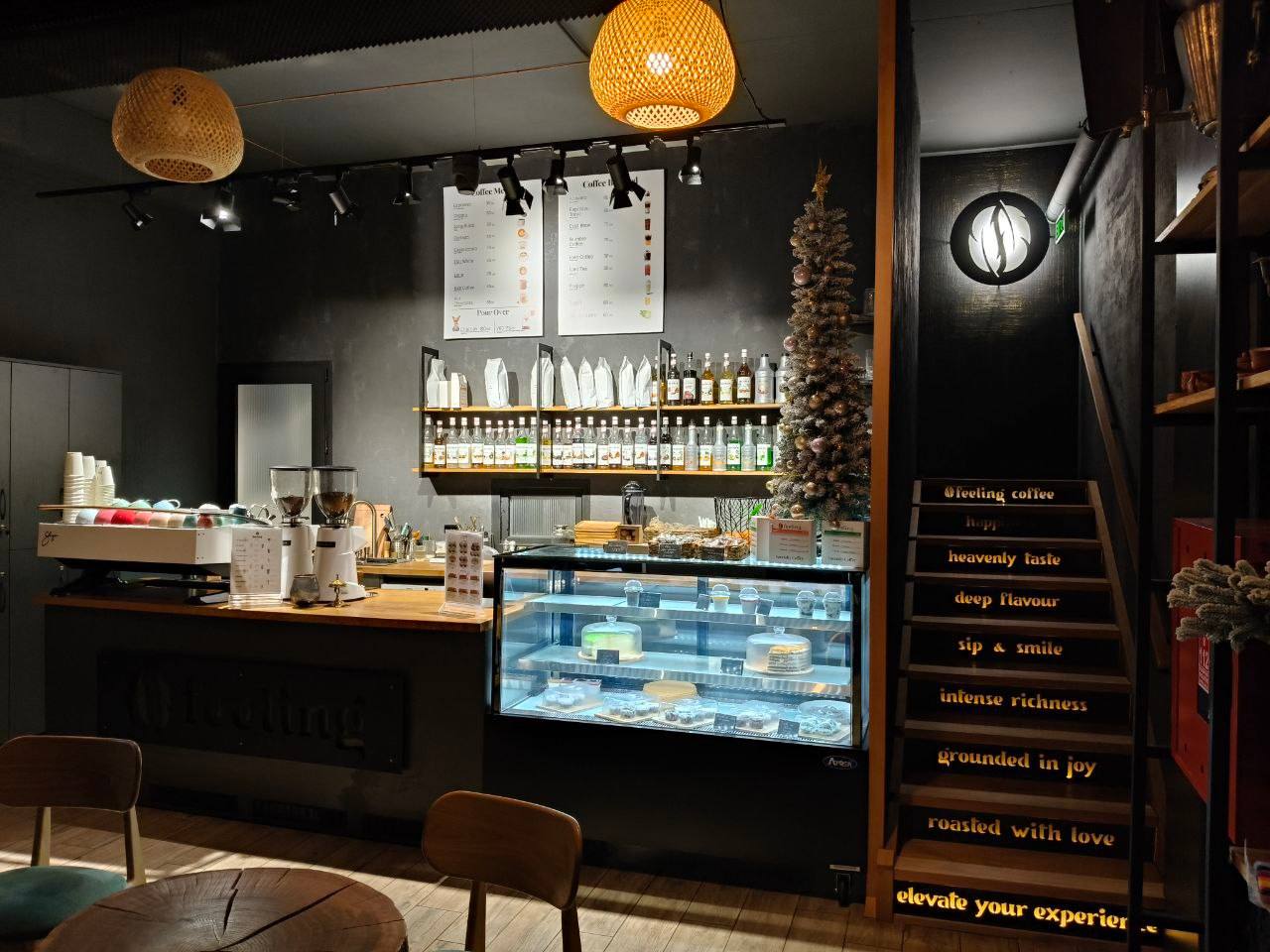 Modern cafe counter with pastry display, pendant lighting, and branded interior