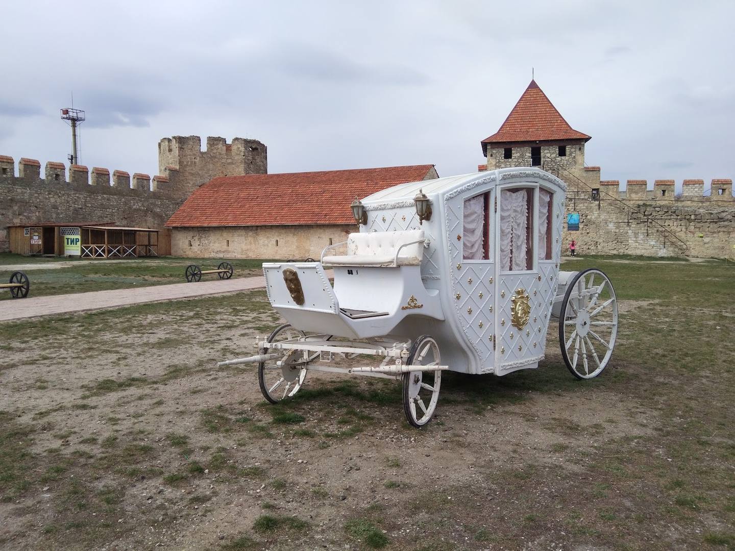 Decorative wedding carriage at fortress venue with medieval towers and walls