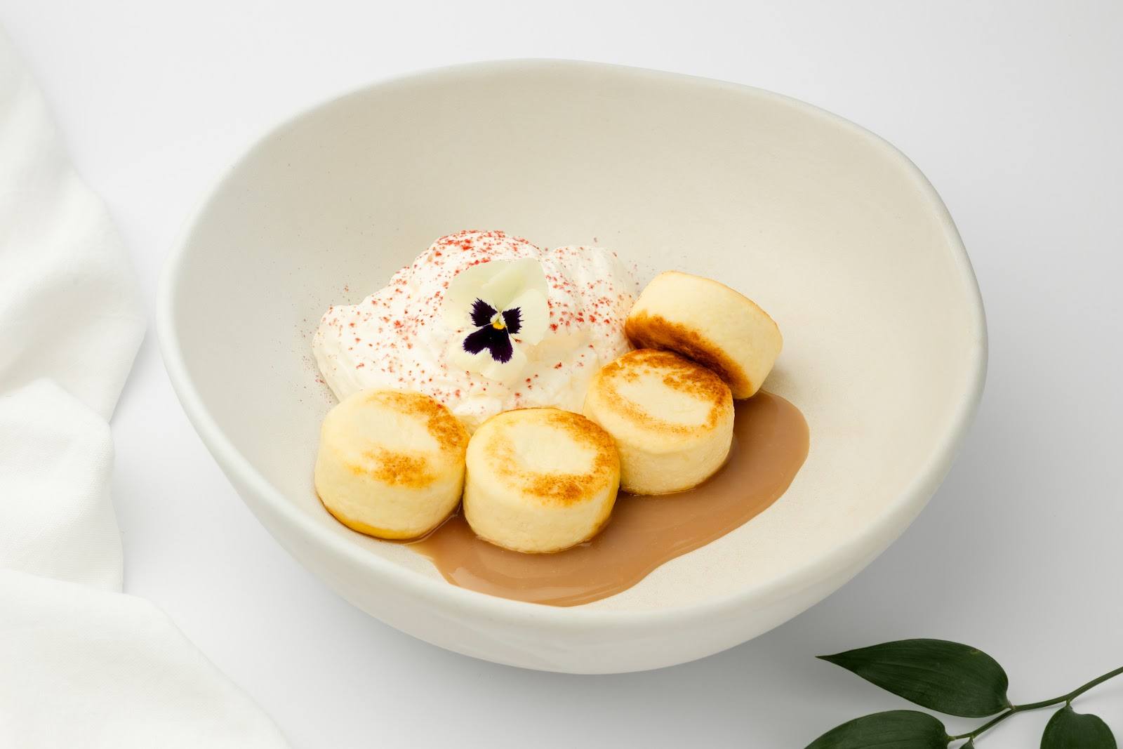 Creatively plated scallops with cauliflower mousse and caramelized elements