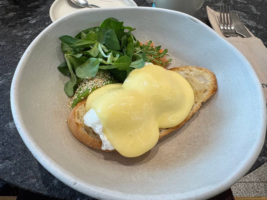 Eggs Benedict with toasted bread and fresh arugula salad