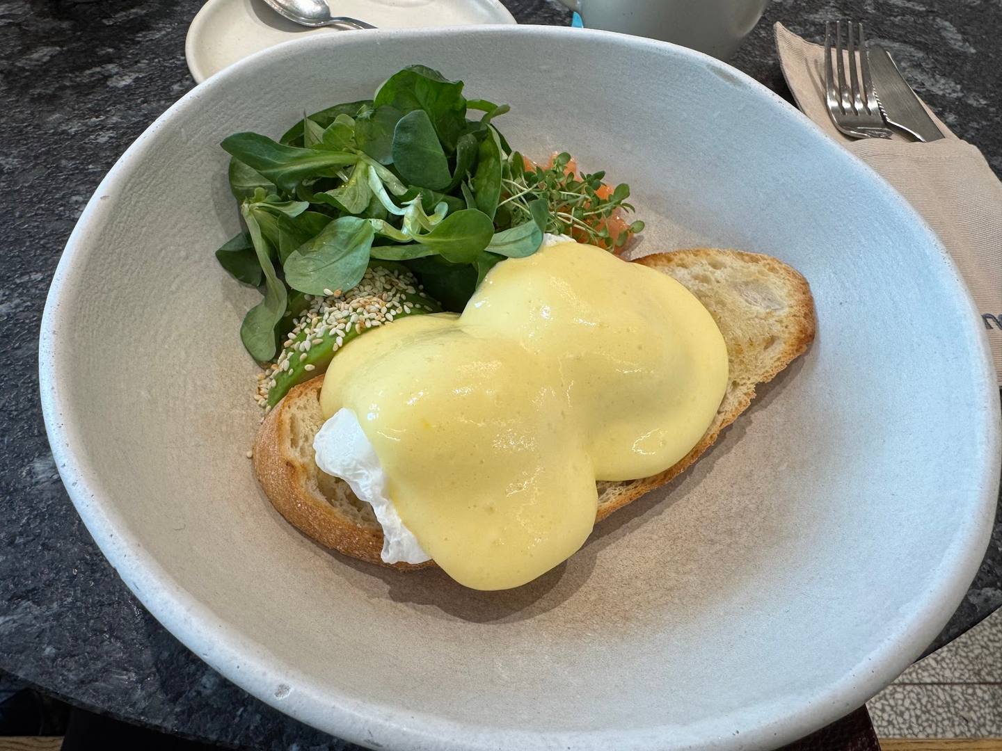 Eggs Benedict with toasted bread and fresh arugula salad