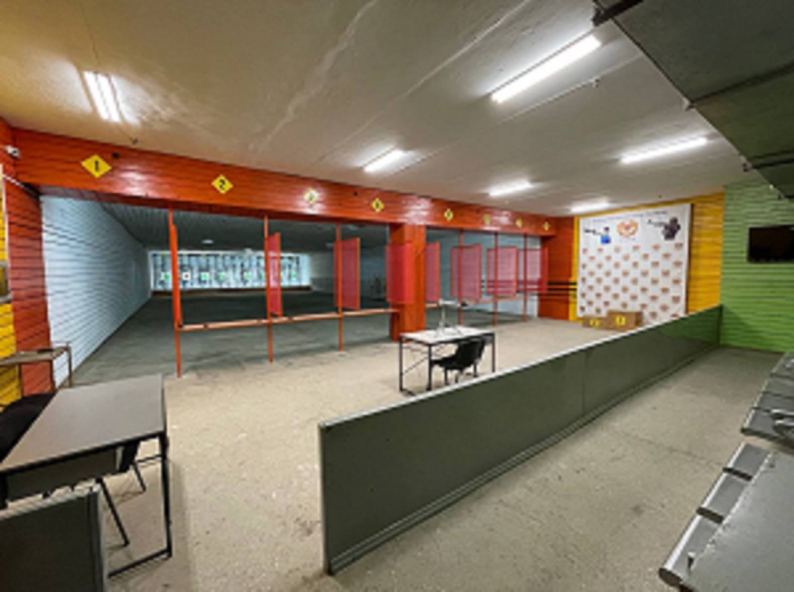 Indoor sports facility with table tennis tables, colored walls, and equipment