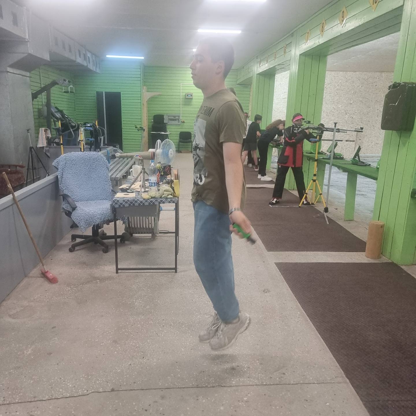 Shooting range interior with rifle stations and green wall partitions