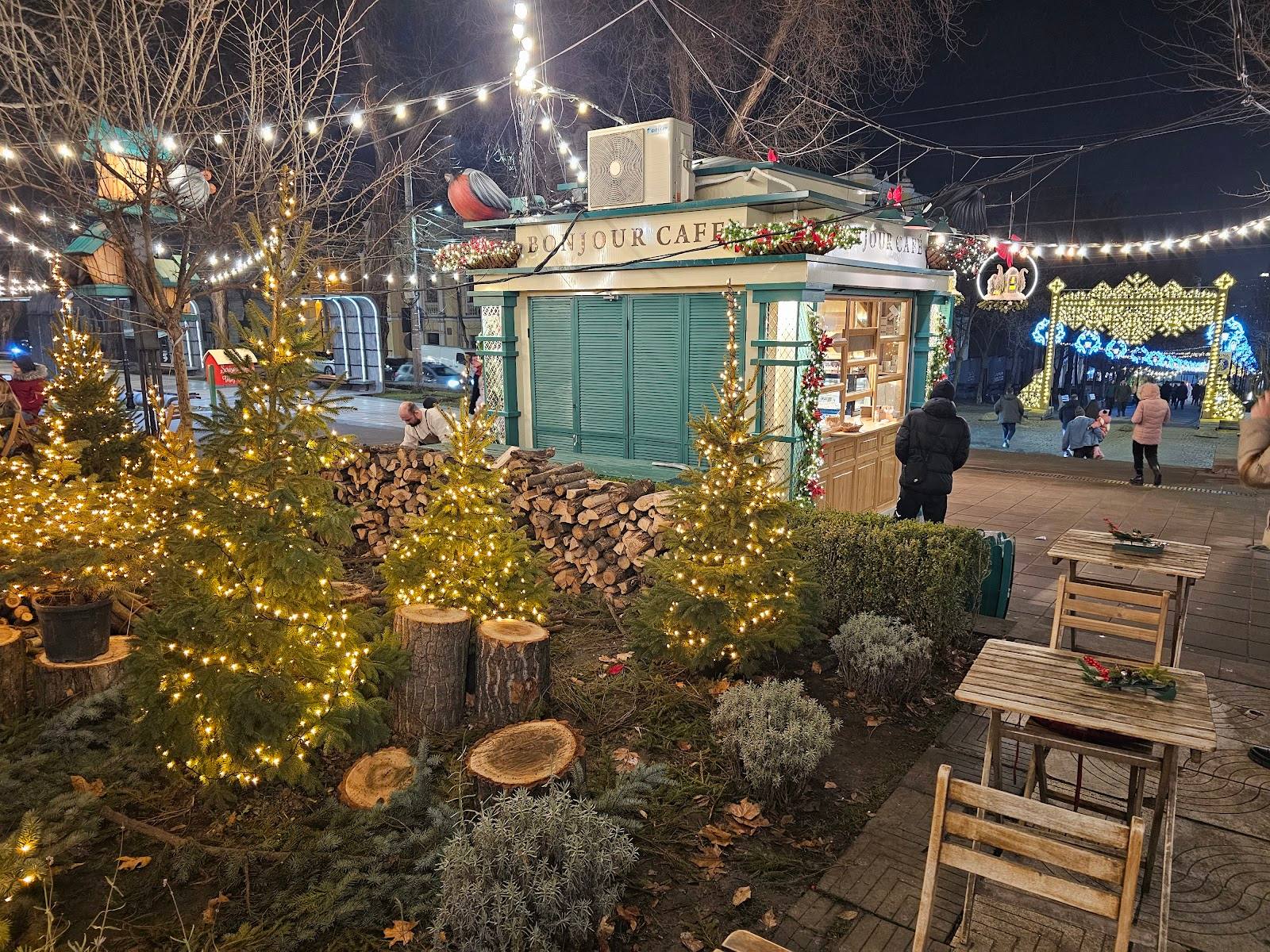 Holiday market kiosk with festive decorations and twinkling lights in evening setting