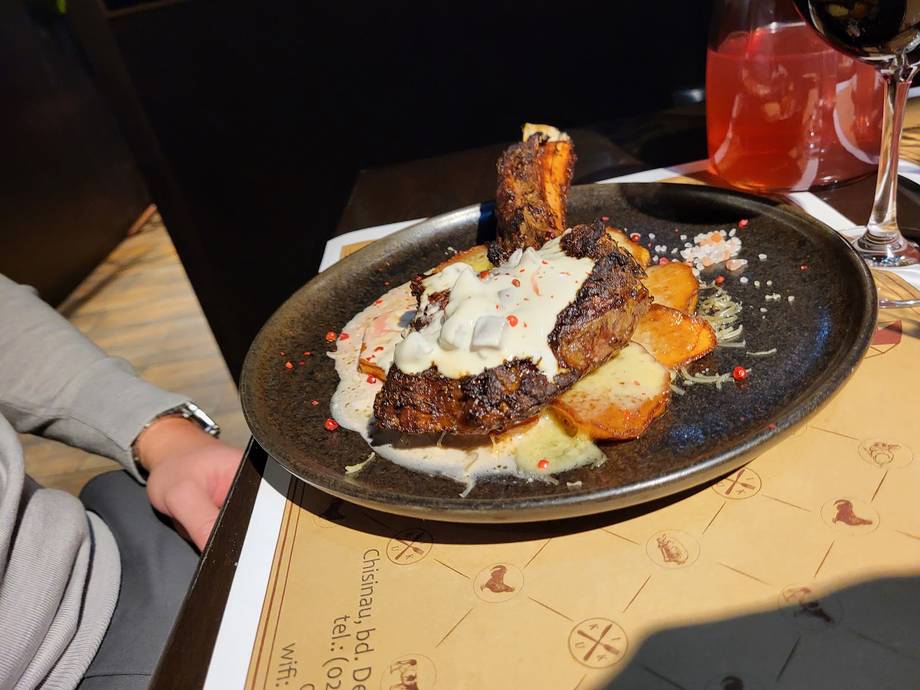 Seared steak with potato and cream sauce on black cast iron plate