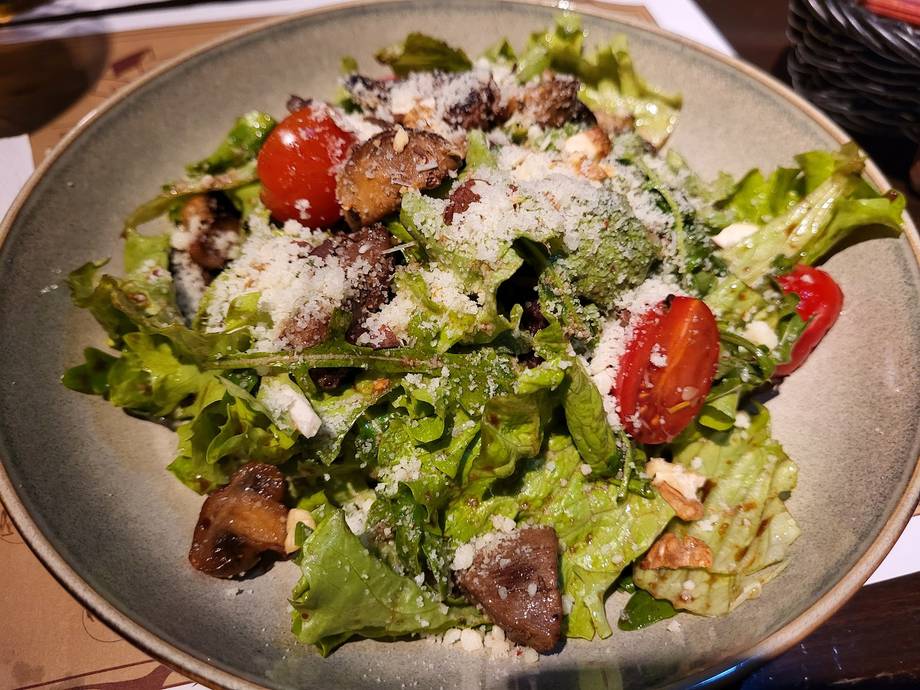 Gourmet salad with leafy greens, croutons, and shaved cheese