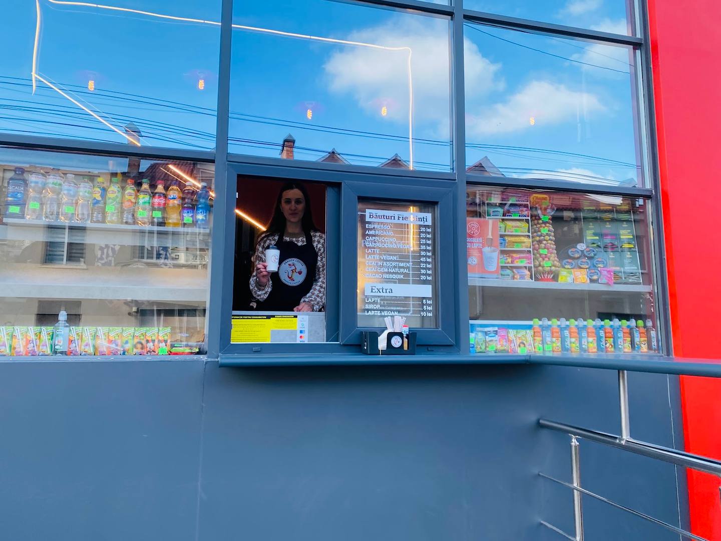 Colorful kiosk storefront with display windows and vendor visible