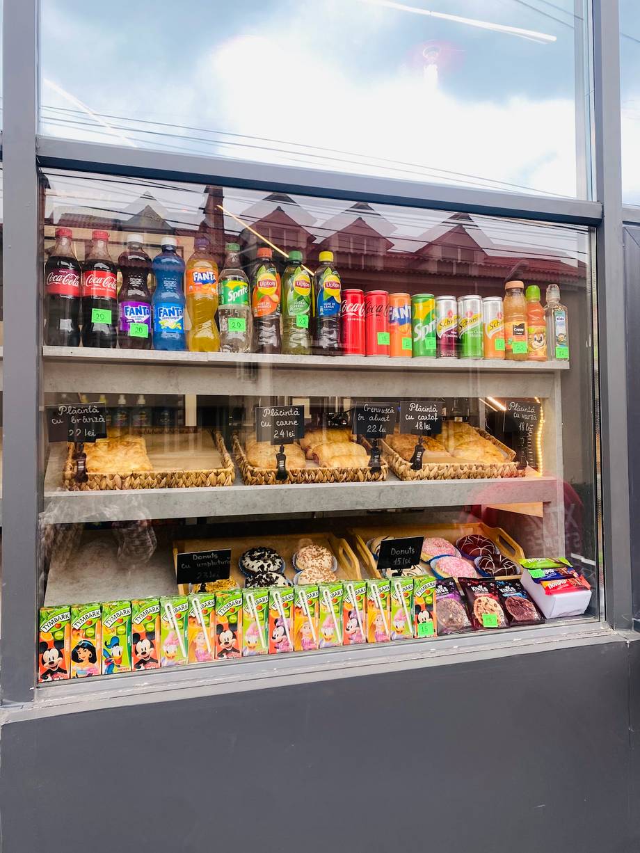 Shop window display with beverages, snacks and packaged goods on shelves