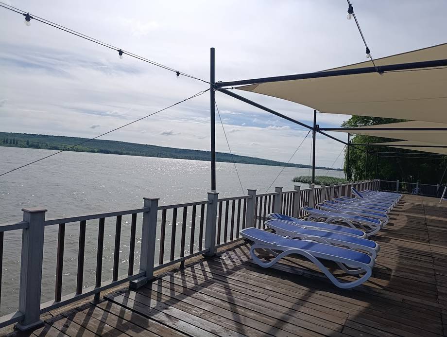 Waterfront terrace with lounge chairs overlooking the Dniester river