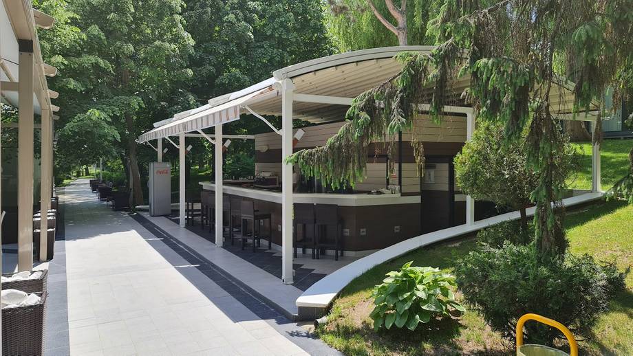 Modern covered terrace with clean lines, concrete flooring, and lush garden surroundings