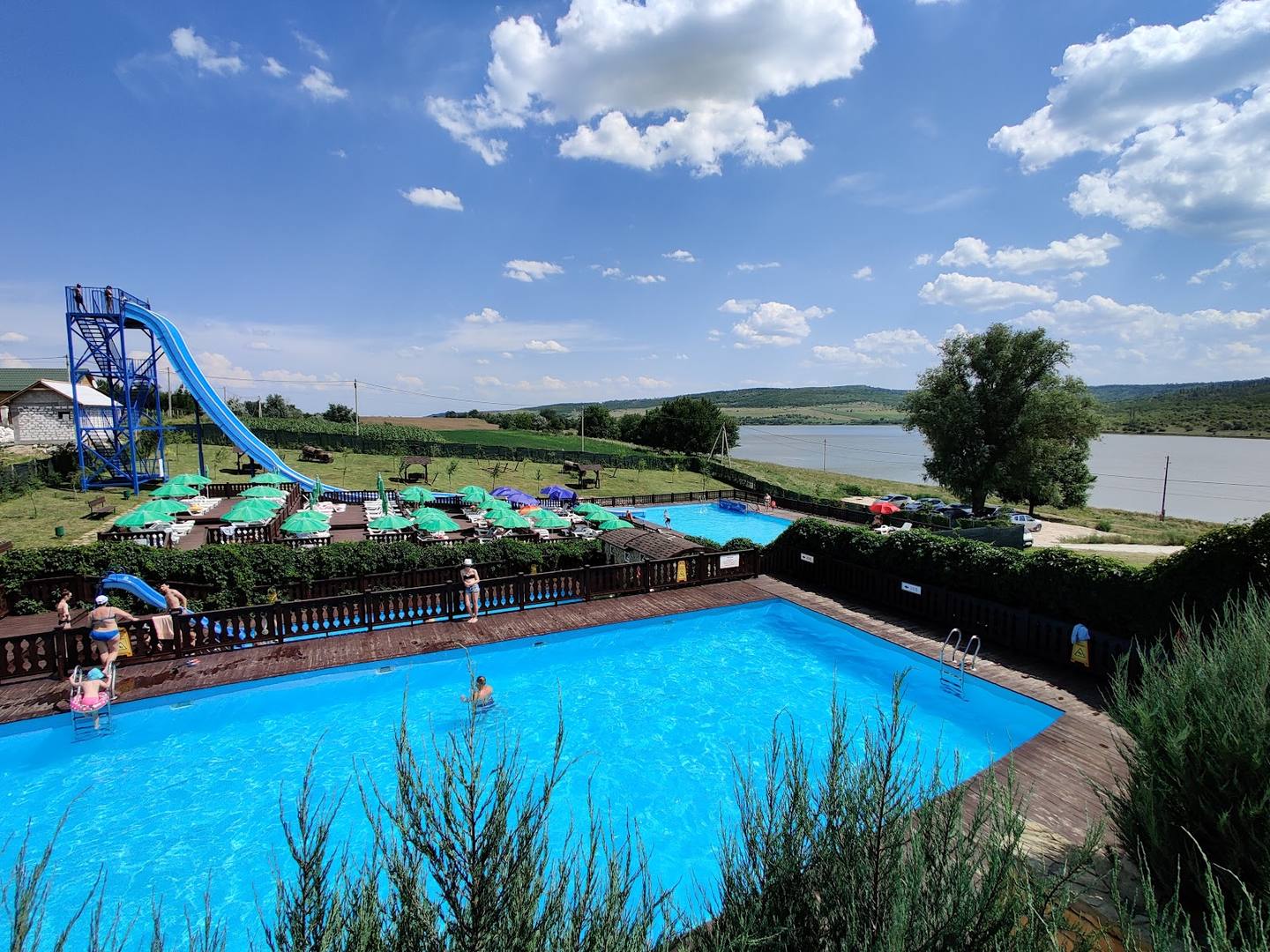 Recreational water park with Olympic-size pool, water slide, and landscaped grounds overlooking the river