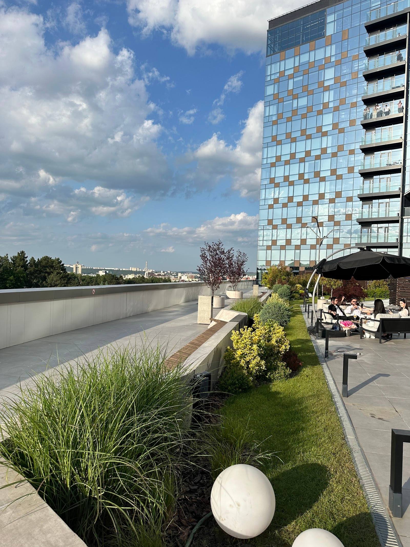 Waterfront terrace with modern building, landscaping, and river views