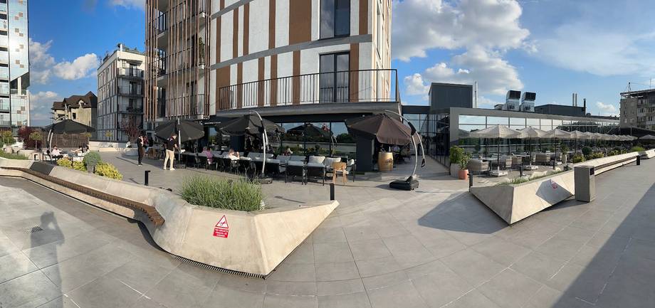 Modern street-level plaza with contemporary building facade and outdoor seating area