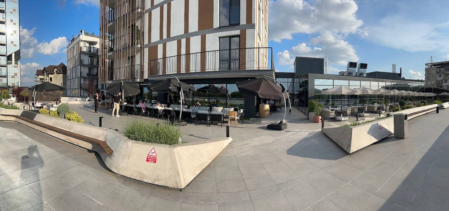 Modern street-level plaza with contemporary building facade and outdoor seating area