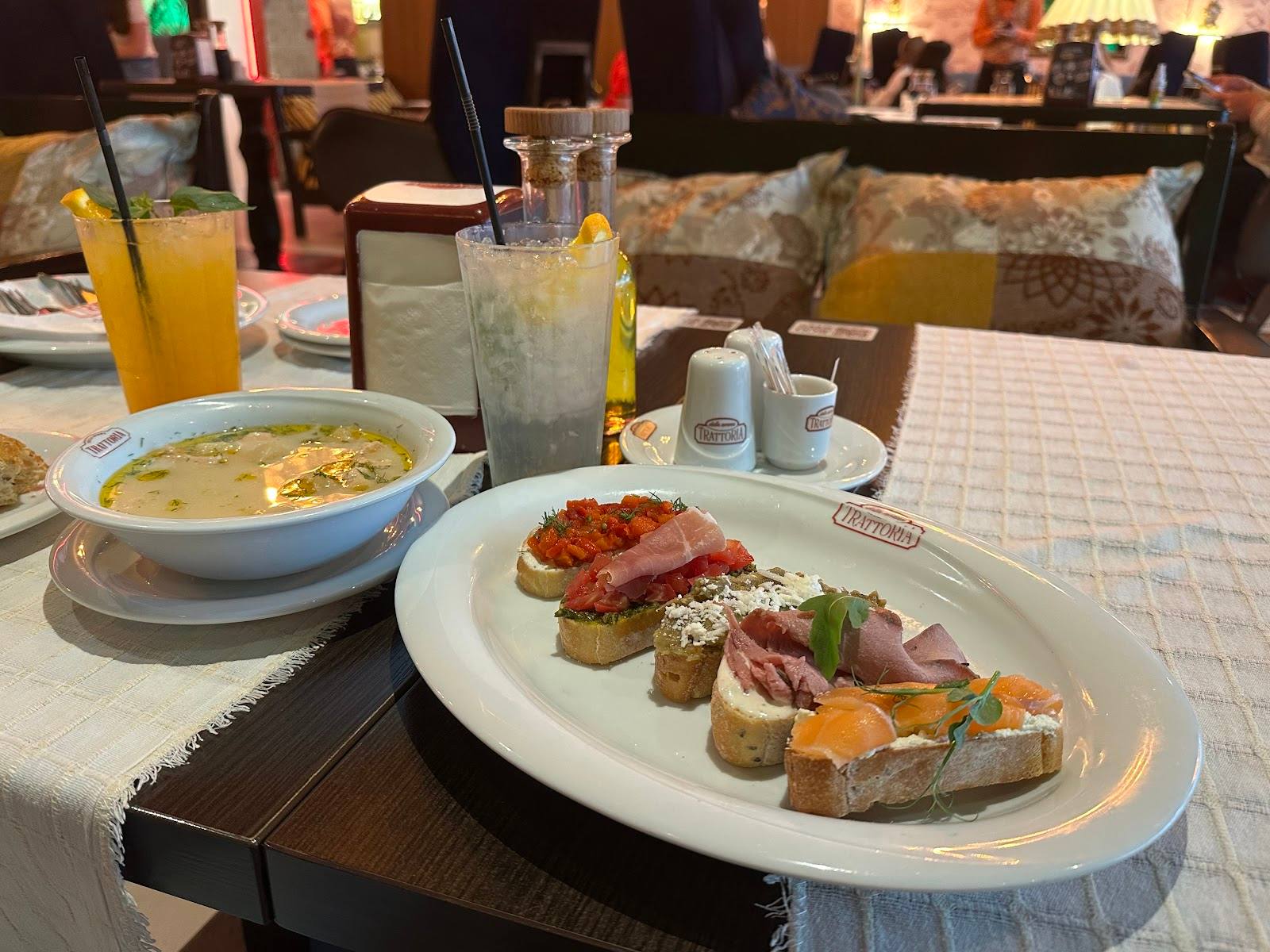 Plated cured meats and soup with fresh juices at table service