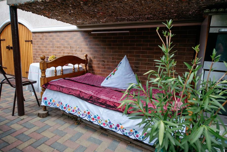 Outdoor display of traditional bedding and home textiles under brick structure