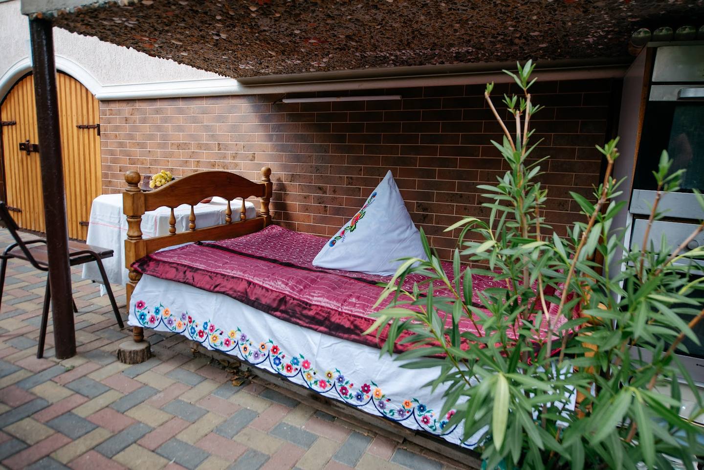 Outdoor display of traditional bedding and home textiles under brick structure