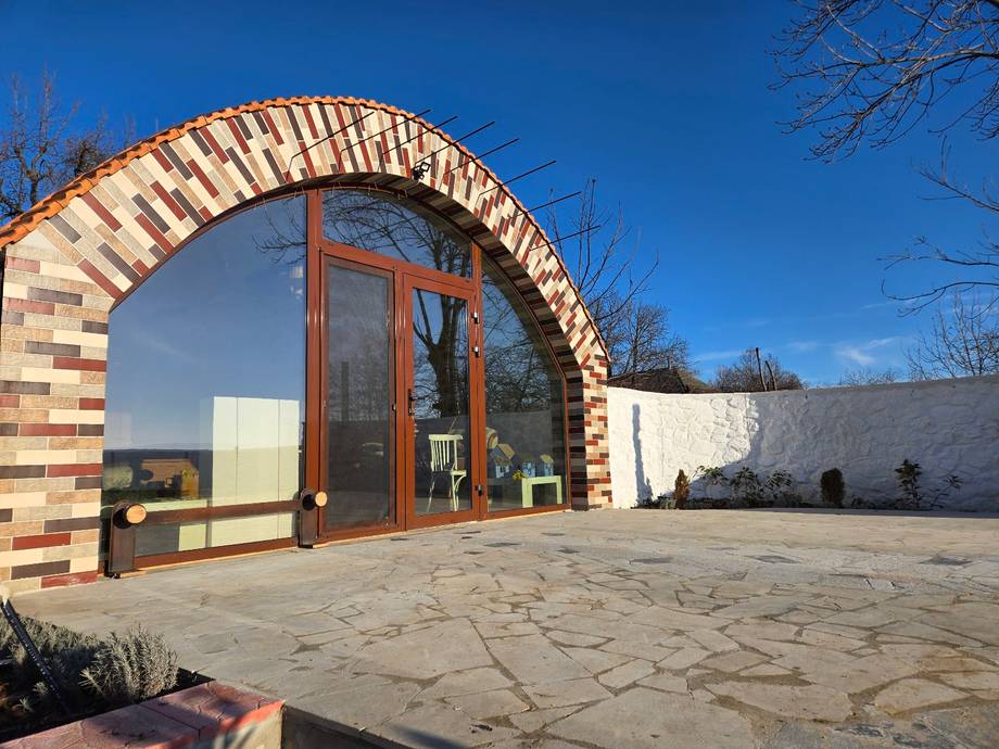 Distinctive brick archway entrance to Moldova monastery with white stone walls and courtyard.