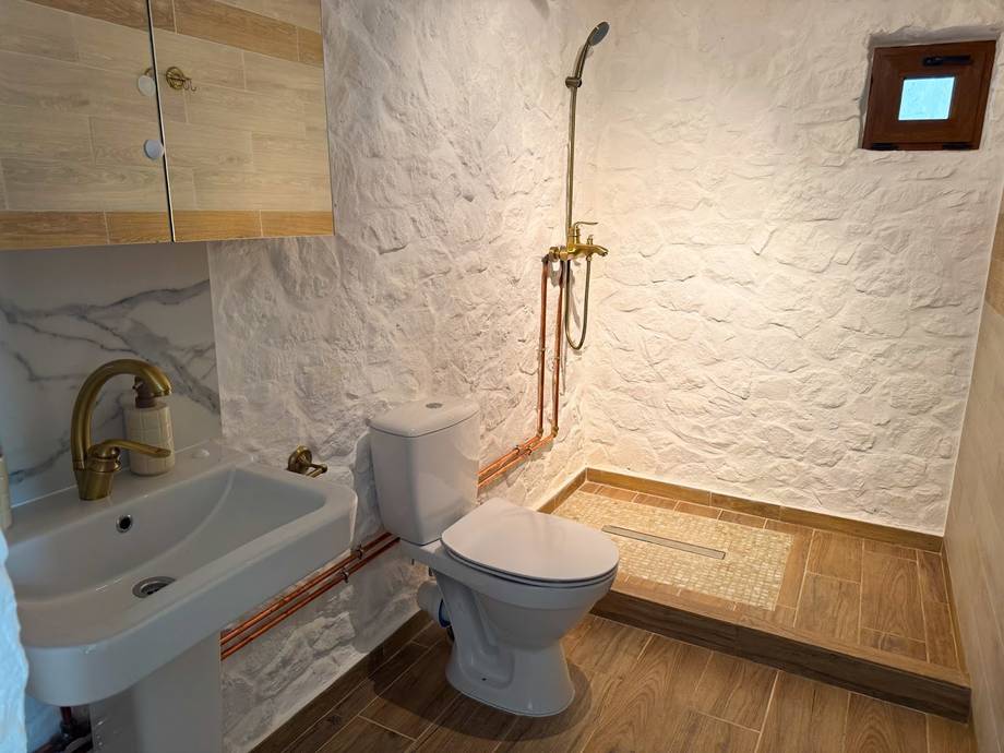 Bathroom interior with white brick walls, sink, and toilet