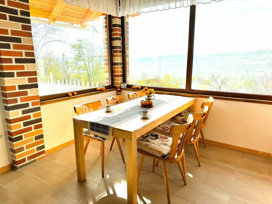 Bright dining room with large panoramic windows overlooking countryside landscape