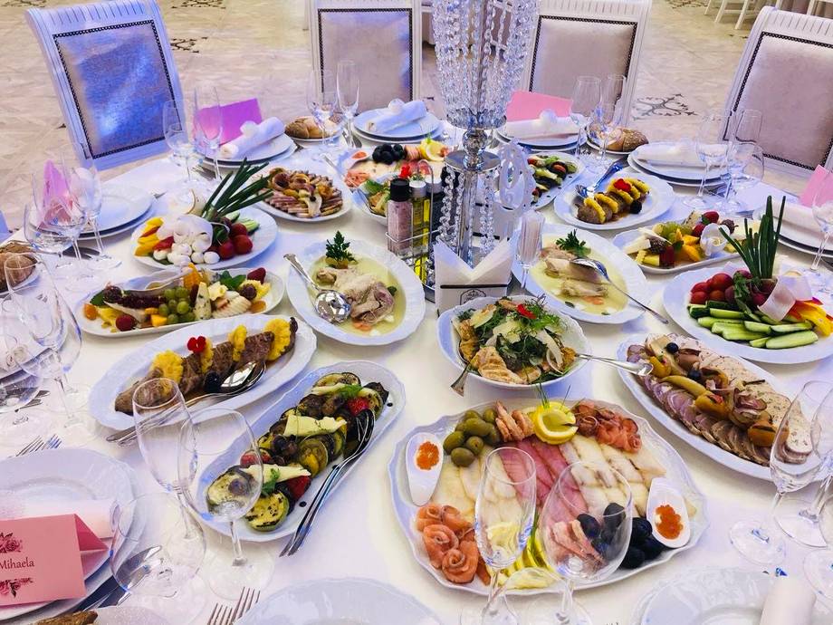 Elegant tablescape with plated dishes and pink floral decor at an outdoor event