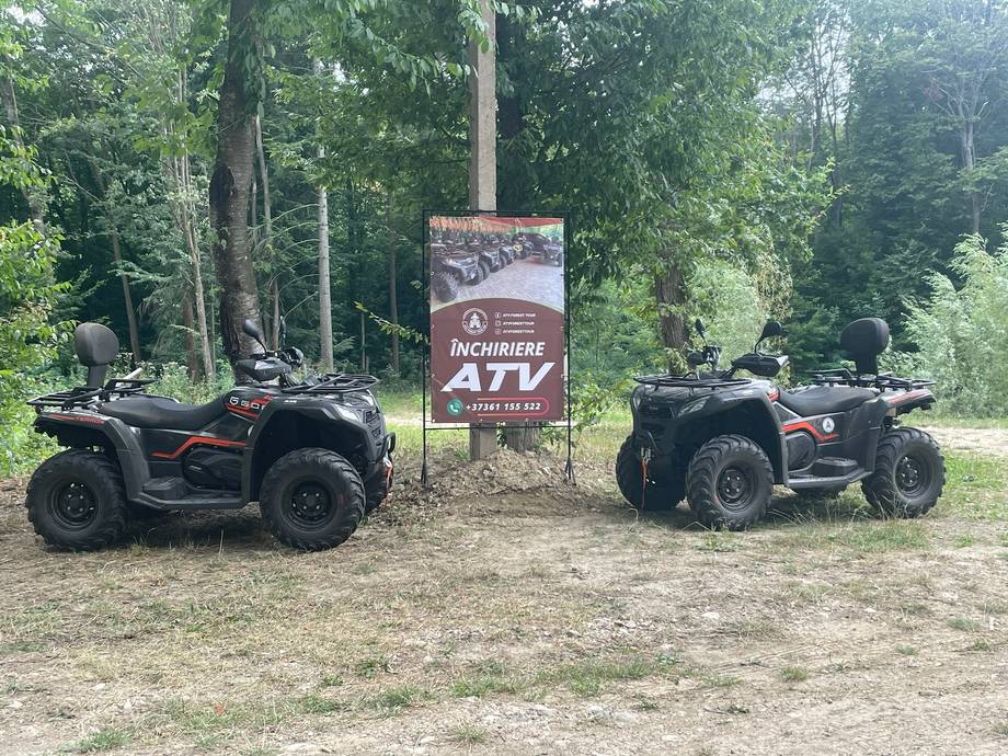 ATV rental venue with quad bikes and branded sign in wooded clearing