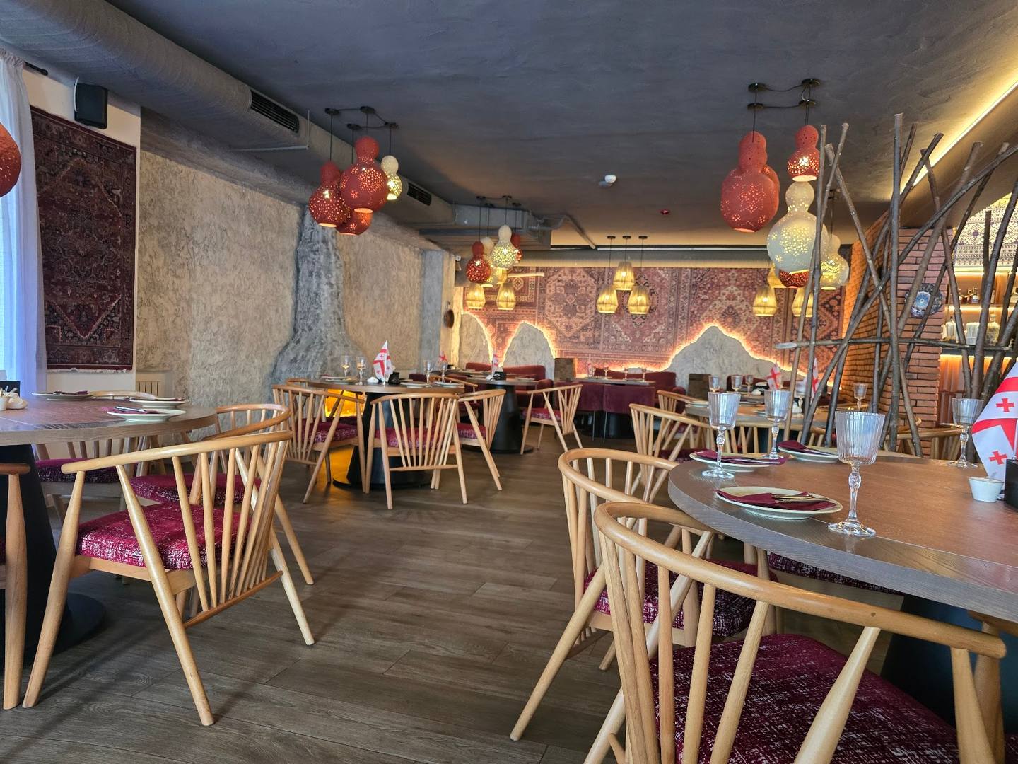 Modern cafe interior with mid-century wooden chairs, exposed brick walls, and artistic red decor elements