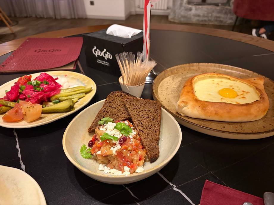 Assorted breakfast dishes including eggs, toast, and fresh salads on a black restaurant table