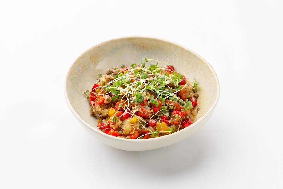 Colorful noodle dish with vegetables and protein in a white bowl