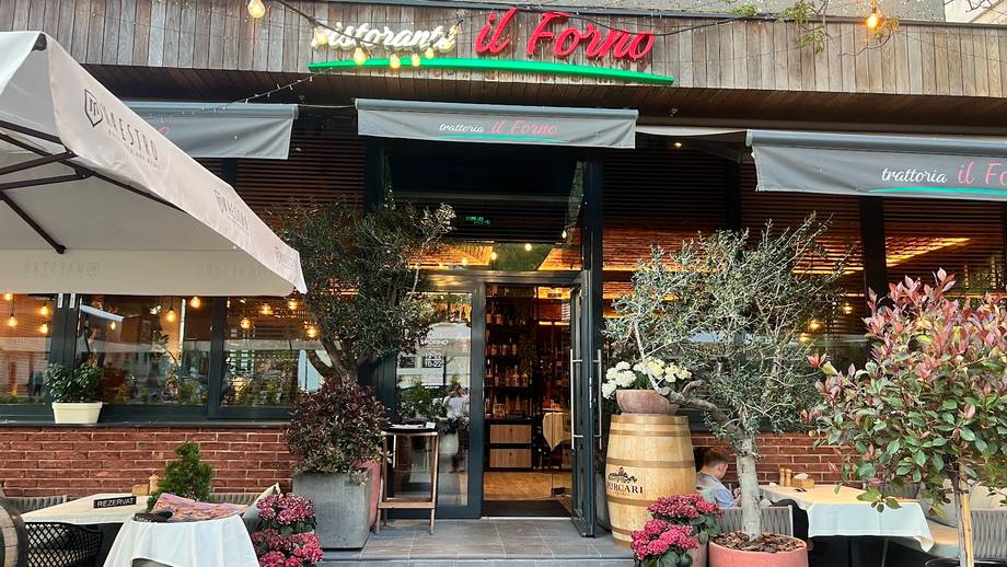 Wine bar storefront with brick facade, signage, outdoor seating and decorative plantings